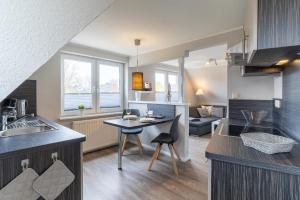 a kitchen and living room with a table and chairs at Duenenzauber in Olsdorf
