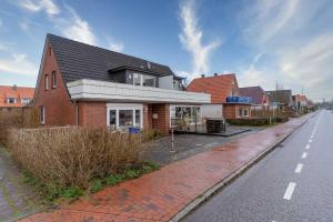 a red brick house on the side of a street at Haus-Springfloot-Whg-2-OG in Olsdorf