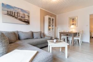 ein Wohnzimmer mit einem Sofa und einem Tisch in der Unterkunft Haus Springfloot, Whg. 1, EG in Olsdorf
