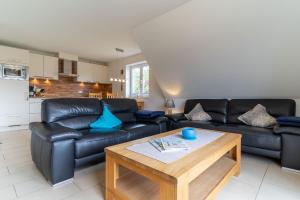 ザンクト・ペーター・オルディングにあるKlein-Friesland-Flutのリビングルーム(黒い革張りのソファ、コーヒーテーブル付)