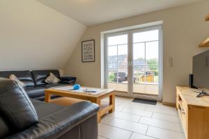 ザンクト・ペーター・オルディングにあるKlein-Friesland-Flutのソファとテーブルのあるリビングルーム