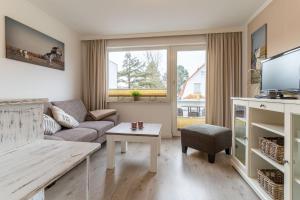 una sala de estar con un sofá y una mesa en Haus-Springfloot-Whg-3-OG, en Olsdorf