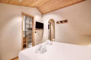 a bedroom with a white bed with towels on it at Appartement 123 (RDP) in Tignes