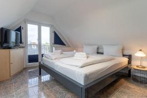 a bedroom with a bed with a tv and a window at Haus-Eriel-OG-rechts in Brösum