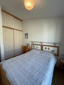 1 dormitorio con 1 cama grande y cabecero de madera en Very bright nest with terrace in the village en La Flotte