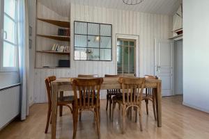 a dining room with a wooden table and chairs at Very bright nest with terrace in the village in La Flotte