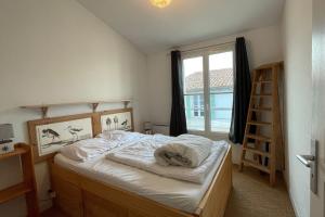 a bedroom with a bed and a window at Very bright nest with terrace in the village in La Flotte