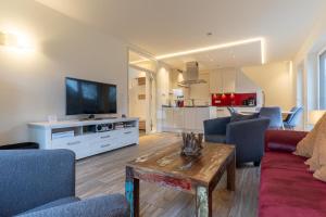 ein Wohnzimmer mit einem Sofa und einem TV in der Unterkunft Wohnung Windböe in Sankt Peter-Ording