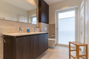 a bathroom with a sink and a toilet and a window at Wohnung-Windboee in Sankt Peter-Ording +14 photos