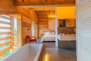 a bathroom with a tub and a bedroom with a bed at Chalet "Lucyvon" exceptional view in Manigod