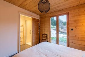 1 dormitorio con cama y ventana grande en Chalet "Lucyvon" exceptional view, en Manigod