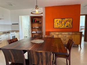 comedor con mesa de madera y sillas en Gardel é Destino Floripa Apartamento 2 quartos, en Florianópolis