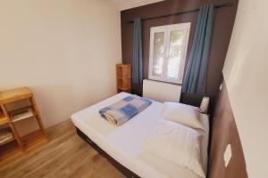 ein kleines Schlafzimmer mit einem Bett und einem Fenster in der Unterkunft Comfortable studio in the historical center in Avignon