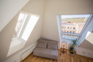 ein Dachzimmer mit einem Stuhl und zwei Fenstern in der Unterkunft JAMA - Bright&Shiny, Balkon, Freies Parken, Zentral, Nähe Bahnhof, WLAN #2 in Würzburg