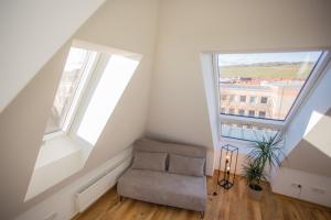 Una habitación abuhardillada con una silla y dos ventanas. en JAMA - Bright&Shiny, Balkon, Freies Parken, Zentral, Nähe Bahnhof, WLAN #2, en Würzburg