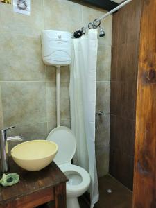y baño con aseo blanco y lavamanos. en Cabaña los coronillos en San Clemente del Tuyú