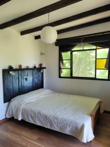 1 dormitorio con 1 cama en una habitación con ventanas en Cabaña los coronillos en San Clemente del Tuyú