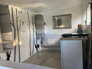 a bedroom with a tree mural on the wall at Fisherman's Cabin on the banks of the River Meon in Southampton