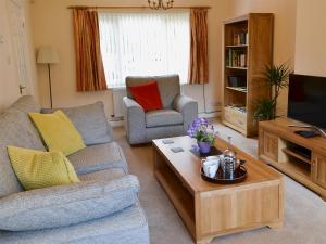 uma sala de estar com um sofá e uma mesa de centro em Millside em Morpeth
