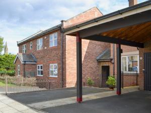 a large brick building with a gate and a building with at Millside in Morpeth