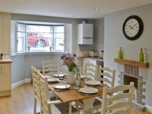 a kitchen and dining room with a table and a clock at Abbeydale Town House in Whitby