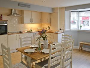 a kitchen with a wooden table with chairs and a table and a table and chairs at Abbeydale Town House in Whitby