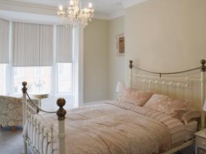 a bedroom with a bed and a chandelier at Abbeydale Town House in Whitby