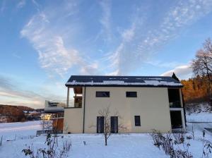 ein weißes Haus mit Schnee auf dem Dach in der Unterkunft Luxurious & lovely vacation home in Prüfingberg
