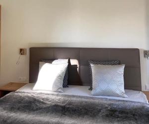 ein Schlafzimmer mit einem Bett mit Kissen darauf in der Unterkunft Luxurious & lovely vacation home in Prüfingberg