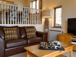a living room with a brown leather couch and a coffee table at Morlais - Hw7599 in Llanaber