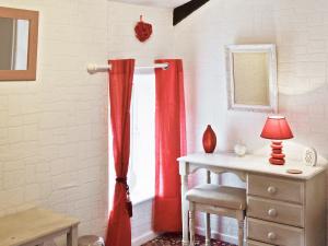 Habitación con cortina de ducha roja y escritorio. en Gamekeepers Apt - Cv20, en Saint Cleer