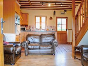 un soggiorno con 2 sedie in pelle e una cucina di Cefn Colwyn Barn - 28198 a Trefeglwys