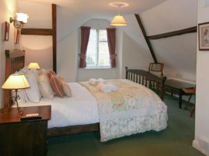 een slaapkamer met een bed met twee handdoeken erop bij Swiss Cottage in Chideock