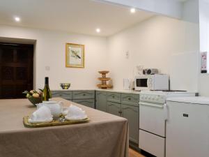 uma cozinha com uma mesa e uma garrafa de vinho em The Granary em Eggleston