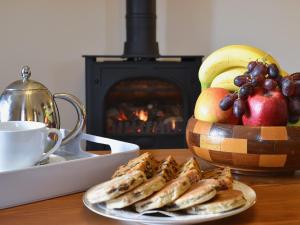 a plate of food on a table with a bowl of fruit at Helygen in Talybont