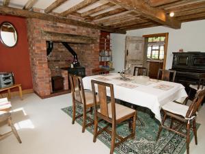 a dining room with a white table and chairs at Field Cottage in Sudbourne