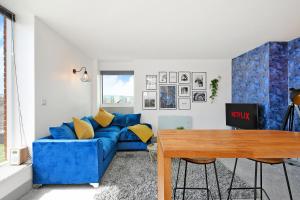 a living room with a blue couch and a table at Sheffield Penthouse with Rooftop Terrace & FREE Parking in Sheffield