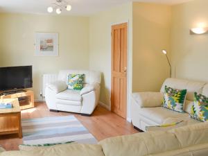a living room with a couch and two chairs at North Shore in Crantock