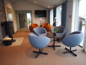una sala d'attesa con sedie e tavolo e una stanza di Hotell Skolestua 