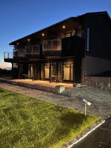 a black house with a lawn in front of it at Hotell Skolestua 