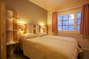 a bedroom with two beds and a window at Sallainen Panvillage in Salla