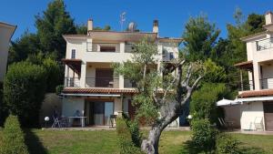 Biały dom z drzewem przed nim w obiekcie Villa Karolina - Halkidiki Kriopigi - 3 bedrooms w mieście Kriopigi