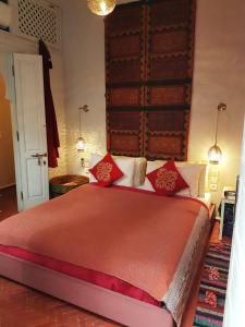 a bedroom with a large bed with red pillows at Riad Laly Tourisme Eclairé Le bijou de la medina in Marrakesh