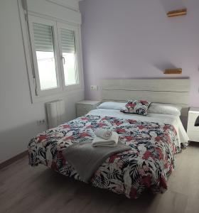 a bedroom with a bed with a comforter on it at ApartmentoTerra de Augas 1 in Caldas de Reis