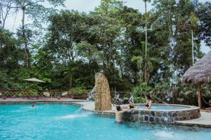 eine Gruppe von Personen in einem Schwimmbad in einem Resort in der Unterkunft Selina Amazon Tena in Tena