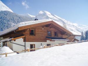 ein Gebäude mit einem schneebedeckten Dach mit einem Berg in der Unterkunft Chalet mit Sauna in Tux - A 246.002-05 in Tux