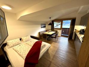 1 dormitorio con cama, mesa y cocina en Klausnerhof en Aschau