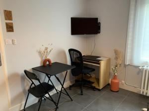 a room with a desk and chairs and a computer at chambre indépendante chez particuliers avec salle de bain privative in Anse