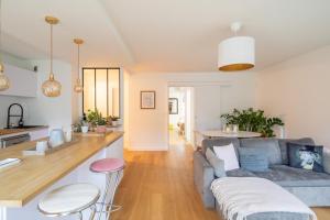 salon i kuchnia z kanapą i ladą w obiekcie Sérénité - 2 chambres - Calme et Verdure w mieście Nantes +6 zdjęć
