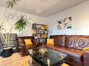a living room with a leather couch and a table at Gorgeous apartment + attentive host + free parking in York